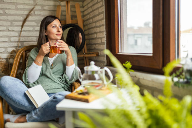 Young Woman drinking her winter tea and welcoming new day stock photo