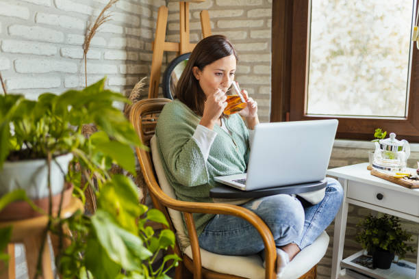 młoda kobieta pije herbatę zimową podczas pracy w domu - business styles foods and drinks drinking zdjęcia i obrazy z banku zdjęć