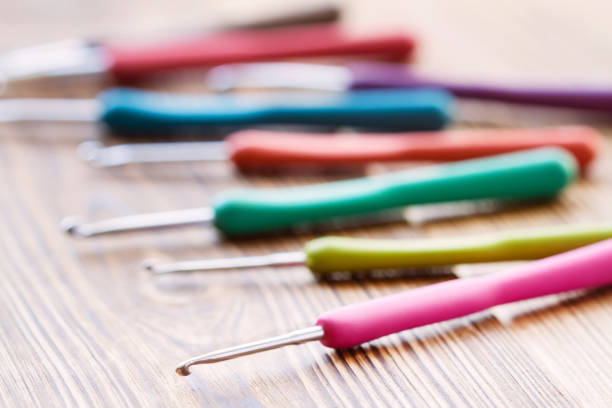 istock A set of multicolored crochet hooks on a wooden background. Close-up, selective focus 1281961864