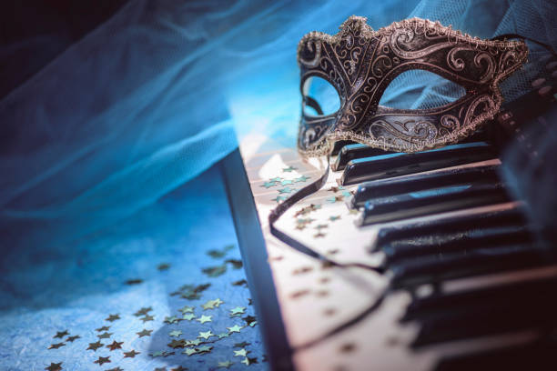 Carnival mask and piano keyboard with confetti stock photo