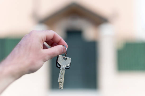 istock hands holding keys with a house in the background 1281963925