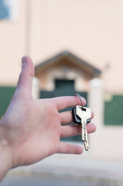 istock hands holding keys with a house in the background 1281963944