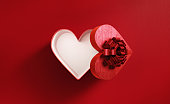 Heart Shaped Red Gift Box Tied With Red Ribbon On Red Background - Valentine's Day And Christmas Shopping Concept