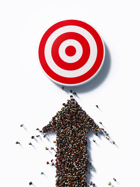 human crowd forming an arrow symbol toward a red bulls eye: marketing and target audience concept - bulls eye dart target dartboard imagens e fotografias de stock