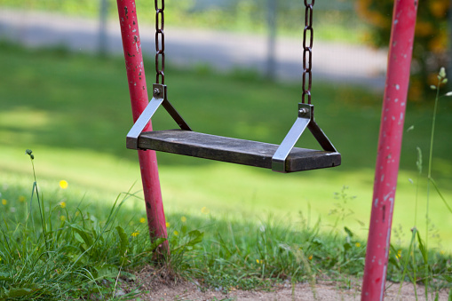 fitness sports fields with stainless steel tools resemble torture tools with chains and handles. soft rubber surface sports ground outdoor gym. man holds a pulley and strengthens muscles, mulching