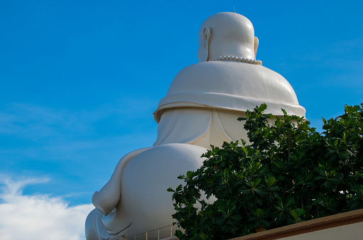 MY THO, VIETNAM - APRIL 25, 2018: Massive statue of the Sitting Smiling Buddha at the Vinh Tranh Pagoda in My Tho, the Mekong Delta