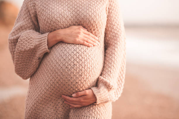 femme enceinte à l’extérieur au-dessus de la mer - être enceinte photos et images de collection