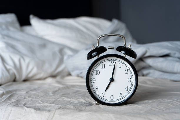 istock Stylish alarm clock with a bell. The hands show 7 hours. Wake up time 1281968193