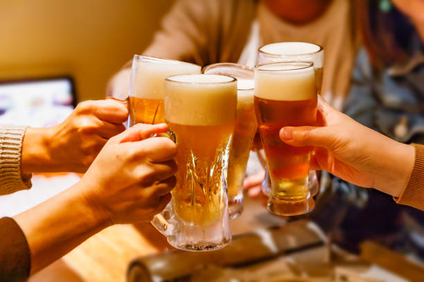 manos y taza de cerveza de muchas personas brindando en una taberna - hora feliz fotografías e imágenes de stock