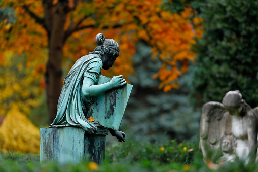 Weathered old copper statue on a cemetery in Germany