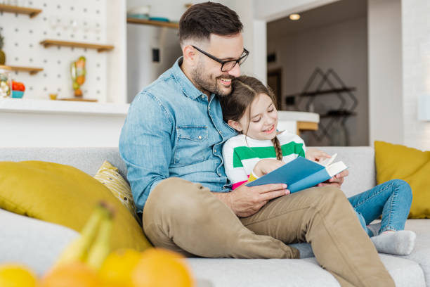 istock Father reads a book to his daughter 1281984364
