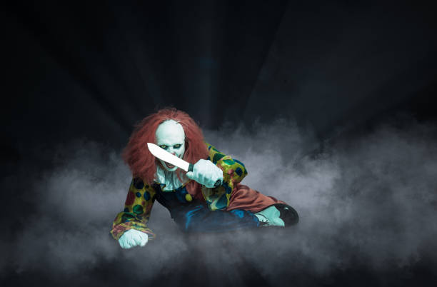 istock crazy clown against an abstract background holds a knife in his hand 1281984399