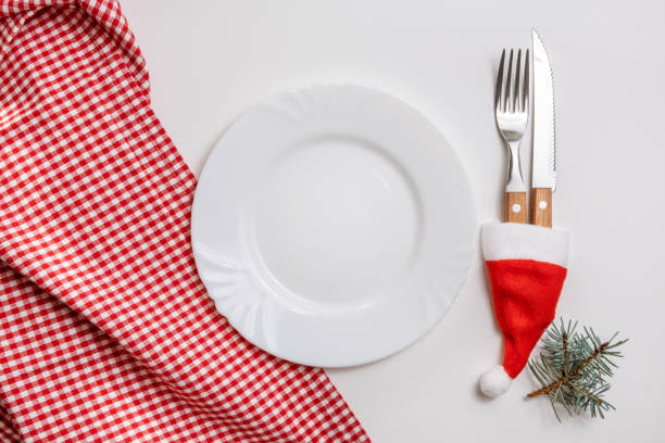 istock Traditional Christmas table place setting with empty white plate, linen napkin, cutlery with festive decorations. New Years background and Holiday concept. Flat lay, top view with copy space 1281984814