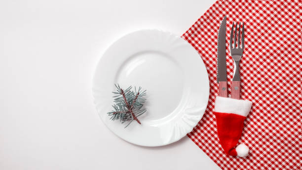 istock Traditional Christmas table place setting with empty white plate, linen napkin, cutlery with festive decorations. New Years background and Holiday concept. Flat lay, top view with copy space 1281984861