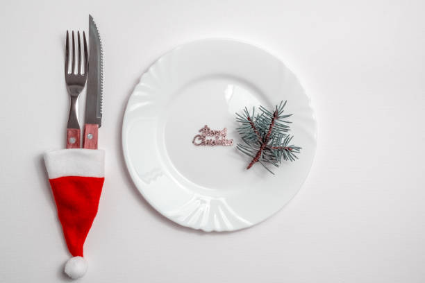 istock Traditional Christmas table place setting with empty white plate, linen napkin, cutlery with festive decorations. New Years background and Holiday concept. Flat lay, top view with copy space 1281985403