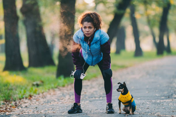 sportiva che fa un respiro dopo aver fatto jogging - running jogging african descent nature foto e immagini stock