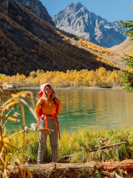 туристка счастливая женщина на озере в осенних горах. горное озеро и туристические - lake alaska mountain mountain range стоковые фото и изображения