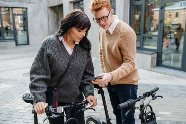istock Lost young couple tugging ebikes, looking at phone screen, figuring the way 1281988364