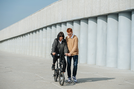 Gf Ride Artist Patient Young Man Helping Girlfriend Ride Ebike Supporting Her On A ...