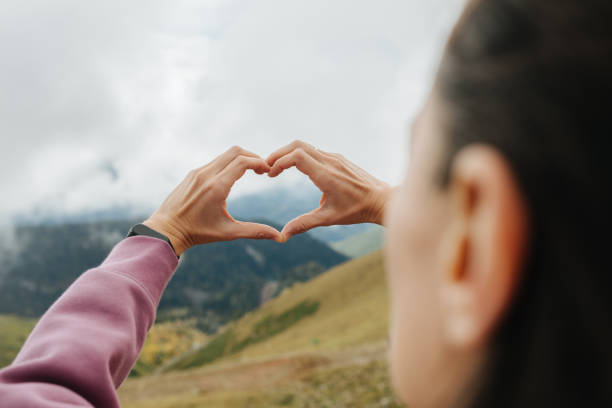 istock Making heart shape with hands high up in cloudy mountains. 1281990502