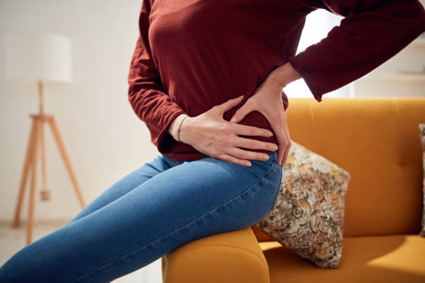 Woman with strong hip pain at home. stock photo