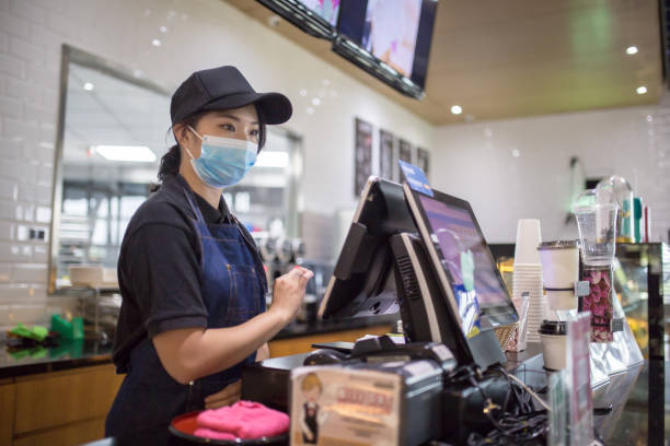 Asian Chinese business owner with face mask keying in check out payment Asian Chinese business owner with face mask keying in check out payment asian cashier stock pictures, royalty-free photos & images