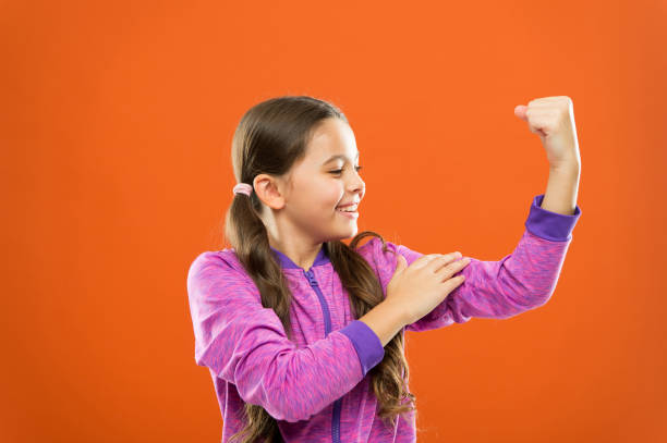 Strong and powerful. Raising strong kids. Satisfied with her strong healthy body. Feeling strong. Child cute girl show biceps power and strength. Girls rules concept. Upbringing advices for girls.