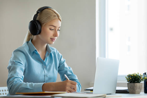 istock Smiling girl with headset studying online 1281998691