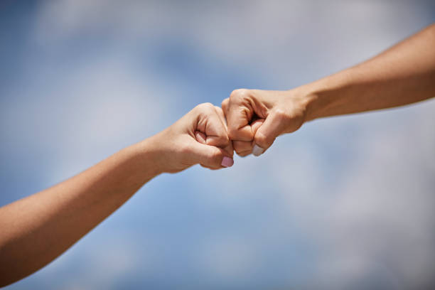 istock Two Hispanic young women bumping fists 1281999733