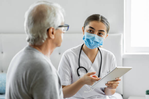istock Doctor and patient on medical consultation using digital tablet at patient's house 1282000176