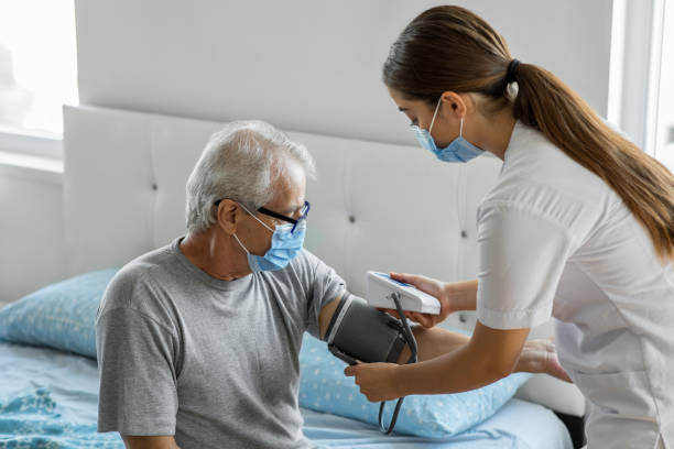 집에서 환자의 혈압을 확인하는 의사 - nursing home nurse blood pressure gauge home caregiver 뉴스 사진 이미지