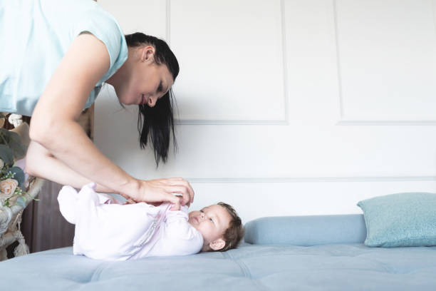 istock Caring mother with baby daughter on sofa at home 1282002290