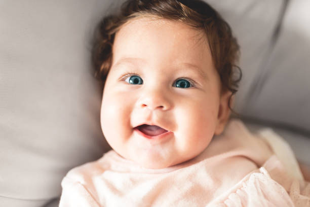 istock Baby girl sitting on sofa at home 1282002376