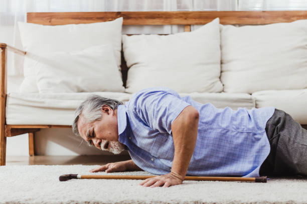 asian senior man falling down lying on floor at home alone - cair no sofá imagens e fotografias de stock