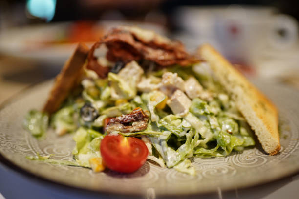 istock Well decorated caesar salad in plate in restaurant 1282008411