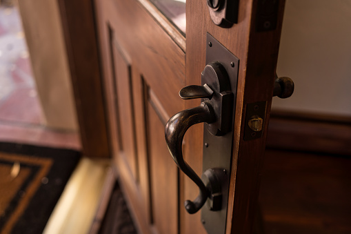 Wooden Front Door Left Open - Door knob and lock detail with door left ajar. Basic home security.