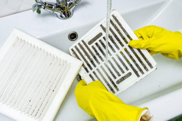 person in a protective rubber glove washes in the sink air filter of the ventilation return duct blocked by dust and debris. cleaning service. - aeration imagens e fotografias de stock