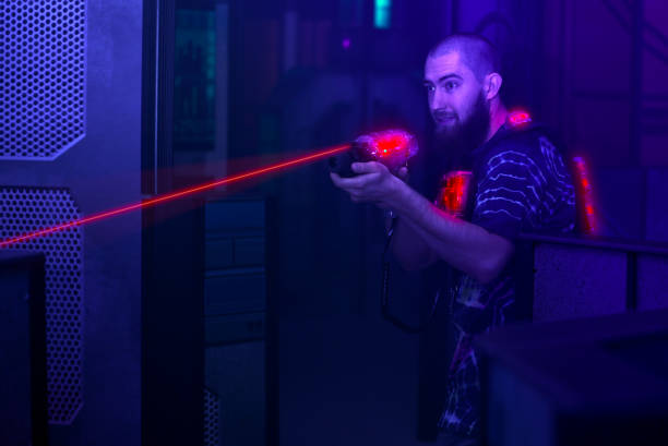 istock laser tag player holding gun shooting light in black light labyrinth 1282015339
