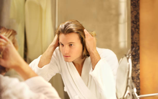 istock Applying the cream.young man looking in the mirror 1282017638