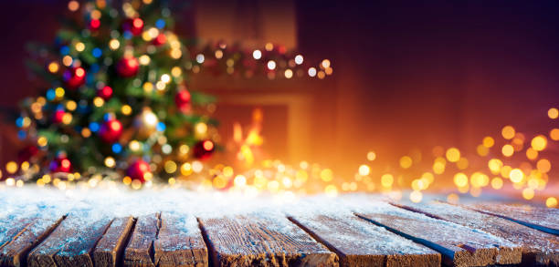 Abstract Christmas - Snowy Table With Bokeh Lights And Defocused Christmas Tree Snowy Table With String Lights And Christmas Tree fireplace stock pictures, royalty-free photos & images
