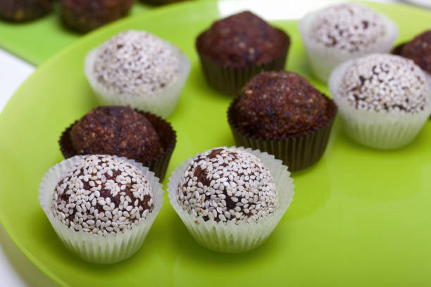 istock Dried fruit and nut sweets. Some are sprinkled with sesame seeds. Made at home in self-isolation during the epidemic. They lie in paper capsules. 1282021153