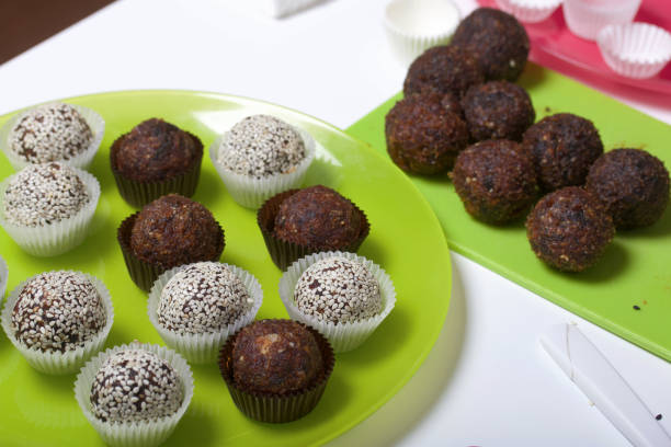 istock Dried fruit and nut sweets. Some are sprinkled with sesame seeds. Made at home in self-isolation during the epidemic. They lie in paper capsules. 1282021161