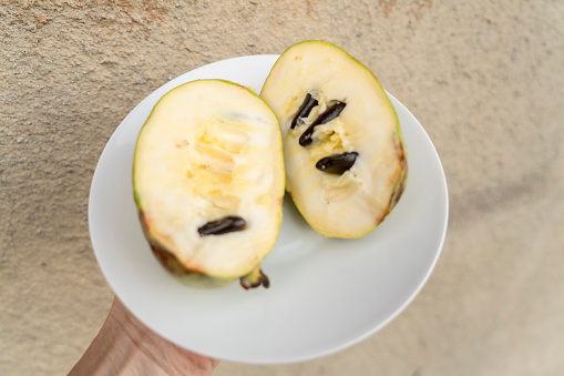 Fruit Asimina Triloba halved on plate