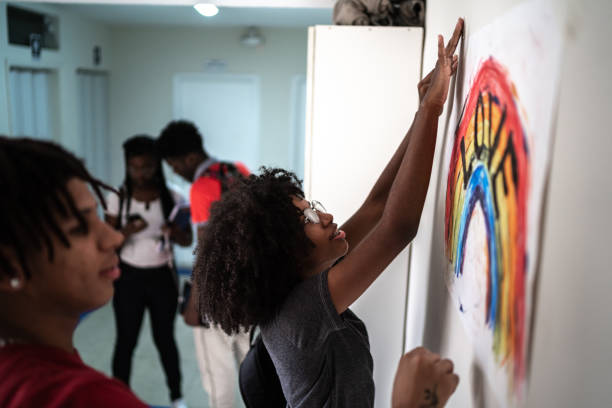 estudiantes arreglando en la pared un cartel sobre los derechos lgbtqi - activista fotografías e imágenes de stock