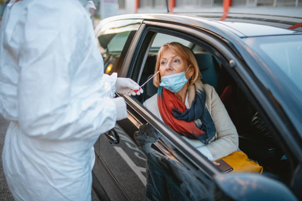 istock Essential Worker with Swab at Drive Thru Medical Test Site 1282026223