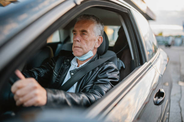 istock Caucasian Senior Male Driving with Lowered Surgical Mask 1282026233
