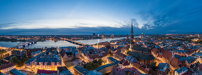 Historical buildings surrounding the St. Peters church in Old Town Riga after sunset