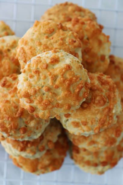istock Image of wire cooling rack, on a marble effect background, containing a stack of freshly baked, homemade cheese scones, elevated view 1282028575