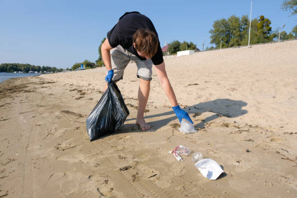 istock A male volunteer cleaning up trash on the beach. Environmental problems. Environmental protection concept. 1282029682