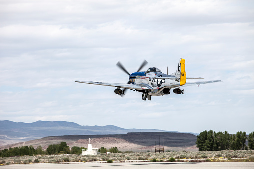Bishop California, USA, May 13, 2010.  Bishop Airport, (KBIH).  \nWWII American Fighter Aircraft\n\nThe North American P 50D Mustang (Blue) armament, two 100lb. Bombs and six 50 Cal Guns.  Top speed of 362 Mph and  could fly over 2000 miles.  The Curtis P 40E Hellcat (Brown) armament two 100 lb. Bombs and six 50 Cal Guns.  Top speed of 296 Mph and could fly over 1,200 miles.  Both aircraft currently registered in Idaho.  Aircraft were in transit and stopped at Bishop Airport for fuel. \n\nBishop Airport was built in 1928 and expanded and operated by the Army Air Corps during WWII.  During the war it was used as a military flight training base and boasted a chow hall and barracks for pilots during training.  Because of its strategic location east of the 12,000 foot tall Sierra Nevada Mountain range Bishop would be used as a Fall Back Base in the event the Japanese military attacked the California coast.
